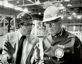 Hardhat management: Baird's look-see approach to running Inco's nickel empire has him donning safety glasses, hardhat and windbreaker as he watches molten copper being poured at company smelter.