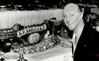 Robert Balzer, food editor of Travel or Holiday magazine, samples stuffed salmon