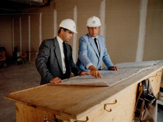 Progress check: Two of the partners in Telfer's Tower Club (Hotels) Ltd., Kerry Baskey, left, and Robert Hanson, inspect the work being done on their luxury hotel on the 28th and 29th floor of the 69-storey Scotia Plaza, being built at King and Bay Sts.
