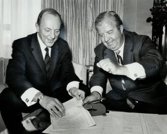 First President of the newly-formed Occidental Life Insurance Co. of Canada is Michael Barnes, 52, left, with Earl Clark, president of the California-based parent company. The two spent an hour and a half yesterday signing hundreds of documents required to launch the firm, which will offer new product lines.
