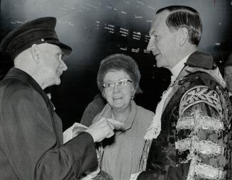 London's Lord Mayor at City Hall, Clad in traditional robes of his office, Sir Robert Bellinger, Lord Mayor of London, shakes hands with Joseph Jenkins, of the Canadian corps of Commissionaires, who came to Canada from London 61 years ago.