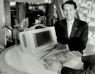 Compact computer: Lewis Bercovitch, head of Compaq Canada, displays new portable computer, the Portable 111, which is reduced in size and weight, but retains full features.