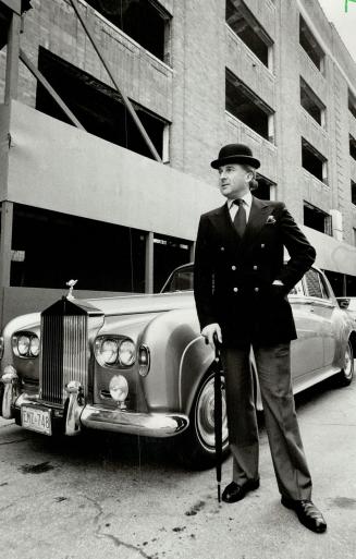 John Blackburn: Looking very, very British (he is) with bowler hat and that fancy car, he poses at site of expensive condominium rising in place of parking garage at Church and Adelaide Sts.