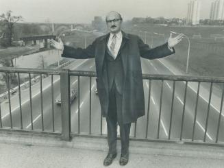 It has to be widened, says Metro traffic commissioner Sam Cass of the Don Valley Parkway as he stands on footbridge crossing it at Riverdale Zoo. Planners estimate it will cost $15 million to widen parkway an extra two lanes, and it's not the right solution adds Cass. In addition, two other street widening programs will cost another $9 million. Cass blames halting of the Spadina Expressway.