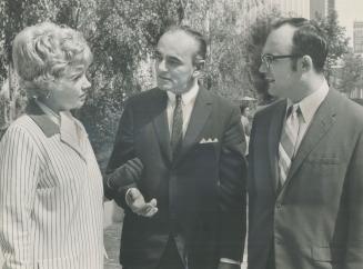 In a huddle during a lunch break today, Walter Choma (centre) his wife and lawyer Sidney J. Silverman talk after leaving courthouse. Choma is charged with trying to bribe former Toronto magistrate David Coon who testified he allowed himself to be bugged so police could record a conversation with Choma.