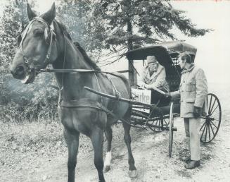 Campaigning by horse and buggy, Gordon Clarke, running for alderman in Scarborough's Ward 12, hands a pamphlet to his neighbor Aubrey Crowhurst, who owns the horse, My Lenny Boy, and the buggy, an antique built by the McLaughlin Carriage Works. Clarke lives in a century-old farmhouse off Meadow-vale Rd. West Hill. He's also using a mobile home in his campaign. Advance polling in city and boroughs will be tomorrow, next Thrusday and next Saturday.