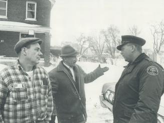 Ordering wreckers away yesterday fromhis expropriated home (in background), Jack Coltman, 60, argues with William Wasylyk (left), the owner of Lakeview Salvage Co., and Constable John Buchanan. Coltman says he has received no settlement yet for his expropriated property on Balfour Ave. and believes under this condition he can claim new rights under recent provincial expropriation legislation. His home was one of nine expropriated for new seperate school.