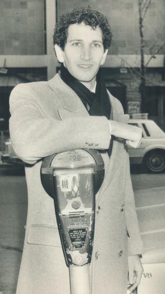 Ticket fight: Law student Robert Cooper leans on a parking meter outside old city hall courts yesterday where he successfully fought against Toronto's sliding parking fine system.