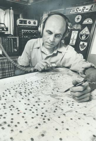 Radio Buff Dick Cummins, president of Scarborough CB radio group, demonstrates how he can control 80 mobile citizen band operators from special trailer, when working with search and rescue operation. Pins on the board indicate their home baes. He is trying to organize all citizens-band groups in Metro into one.