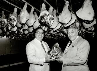 Hamming it up: Domenic, left, and Lelio Cappola have been making prosciutto for 23 years. It's a simple but time-consuming process to make the salt-cured ham that is so popular served with melon. The broghers sell 1,500 hams each week from the Cartwright Ave. location year Yorkdale.