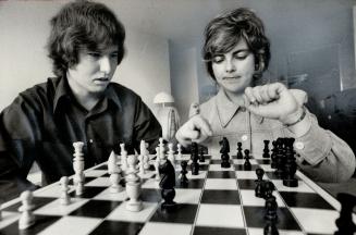 Futures trading in currencies and commodities has paid off handsomely for fomer Windsor high school teacher Jim Carroll, who parlayed $750 into more than $150,000. His new wealth, he says, means he might just play chess for a year in 1974. Here he is enjoying a game with wife Mary Pat. Worldwide shortages have made commodity futures a fertile area for speculation, Carroll points out.