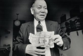 John Chow, who came to Canada in 1922, holds his torn head tax certificate. Some 81,000 Chinese immigrants paid the levy.