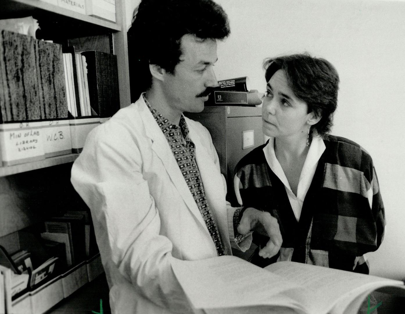 Lamp clinic: Bonnnie Heath, co-ordinator of the lakeshore Area Multi-Service Project, goes over case reports with Dr. Donald Cole, who treats workers made ill by job-related hazards. Cole works at lamp's occupational health clinic, saved by a government grant recently.