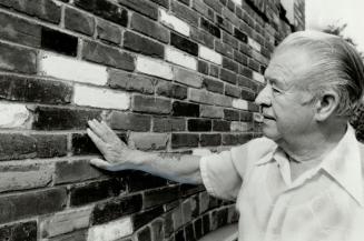 Solid handlwork: Art Cooke spent the summer of '45 chiseling mortar off old bricks to build the home he and his wife still live in on Burnett Ave. Today, a high-rise looms near the site he bought for $350. Above, Cooke admires the sturdy bricks he bought for $352 and hauled in a rented truck from the Swift meatpacking plant.