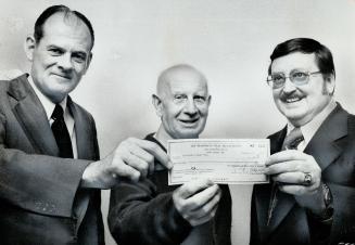 Pensioner swims mile a day: Frank Cooper (middle), 78, swims at least a mile a day this month to raise money for Mississauga Heart Fund. Fund chairman Jack Kehoe (left), Cooper, and Seth Taylor, of Mississauga Real Estate Board, hold $1,000 cheque to fund raised by board's sponsorship of Cooper's swim.