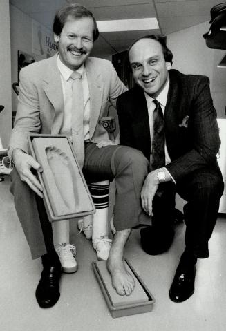 Feet first: Ernie Whitt, left, of the Toronto Blue Jays, has an impression of his foot taken by Glenn Copeland, president of the Feet First store, which will offer physiotherapy for feet as well as sports shoes and custom-made shoe inserts.