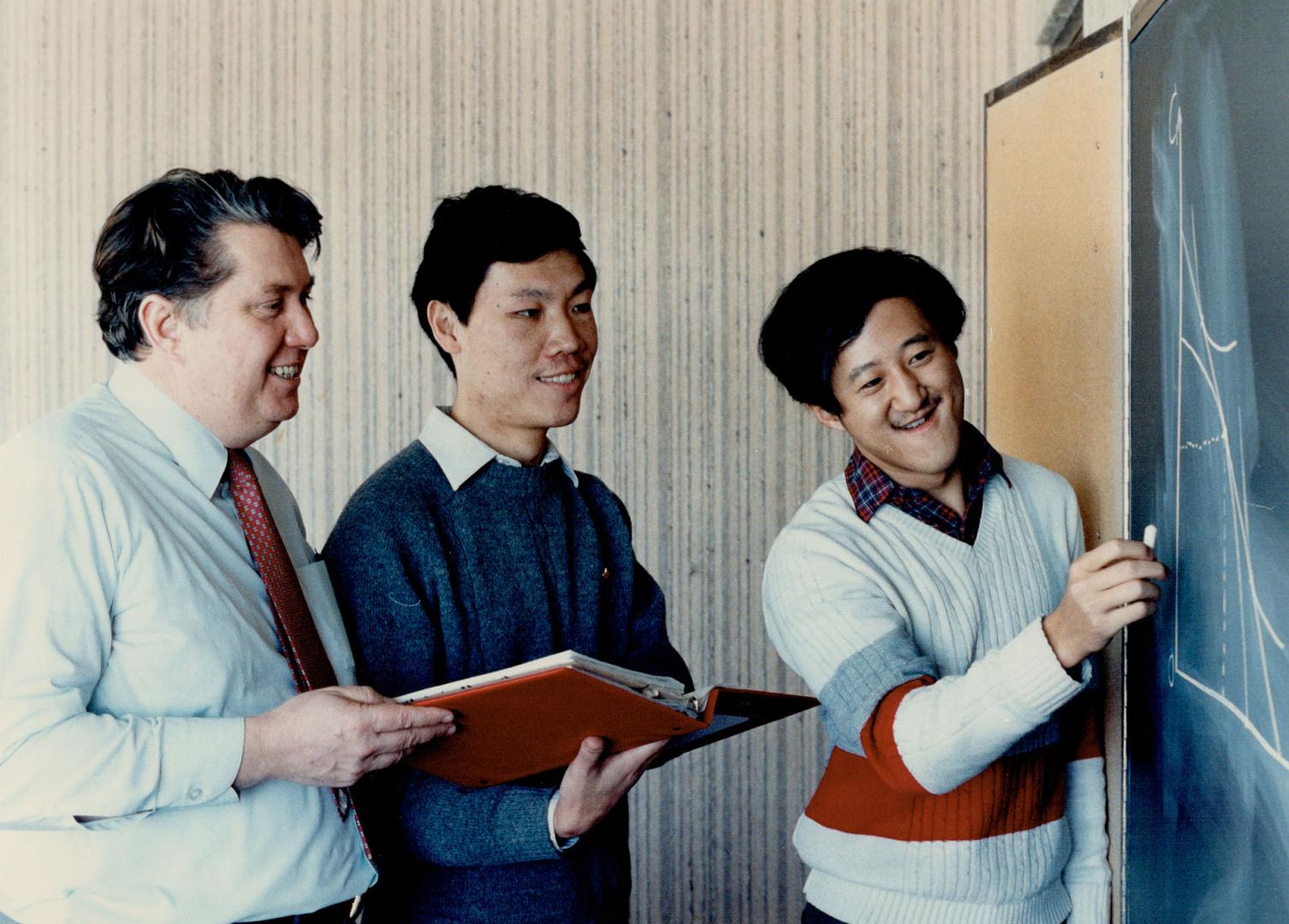 Finer points: York professor Wally Crowston, left, co-ordinator of the university's $1.3 million Canadian International Development Agency program, shows Aiang Teng, centre, and Yisong Tian the finer points of economics and management. The two will return soon to teach in China.