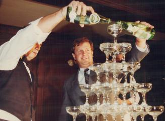 Sparkling Toast: Perrier chief Frank de Vries, right, pours a bottle of the famed French mineral water into stacked glasses at a Toronto restaurant yesterday. The product is returning after a contamination scare.