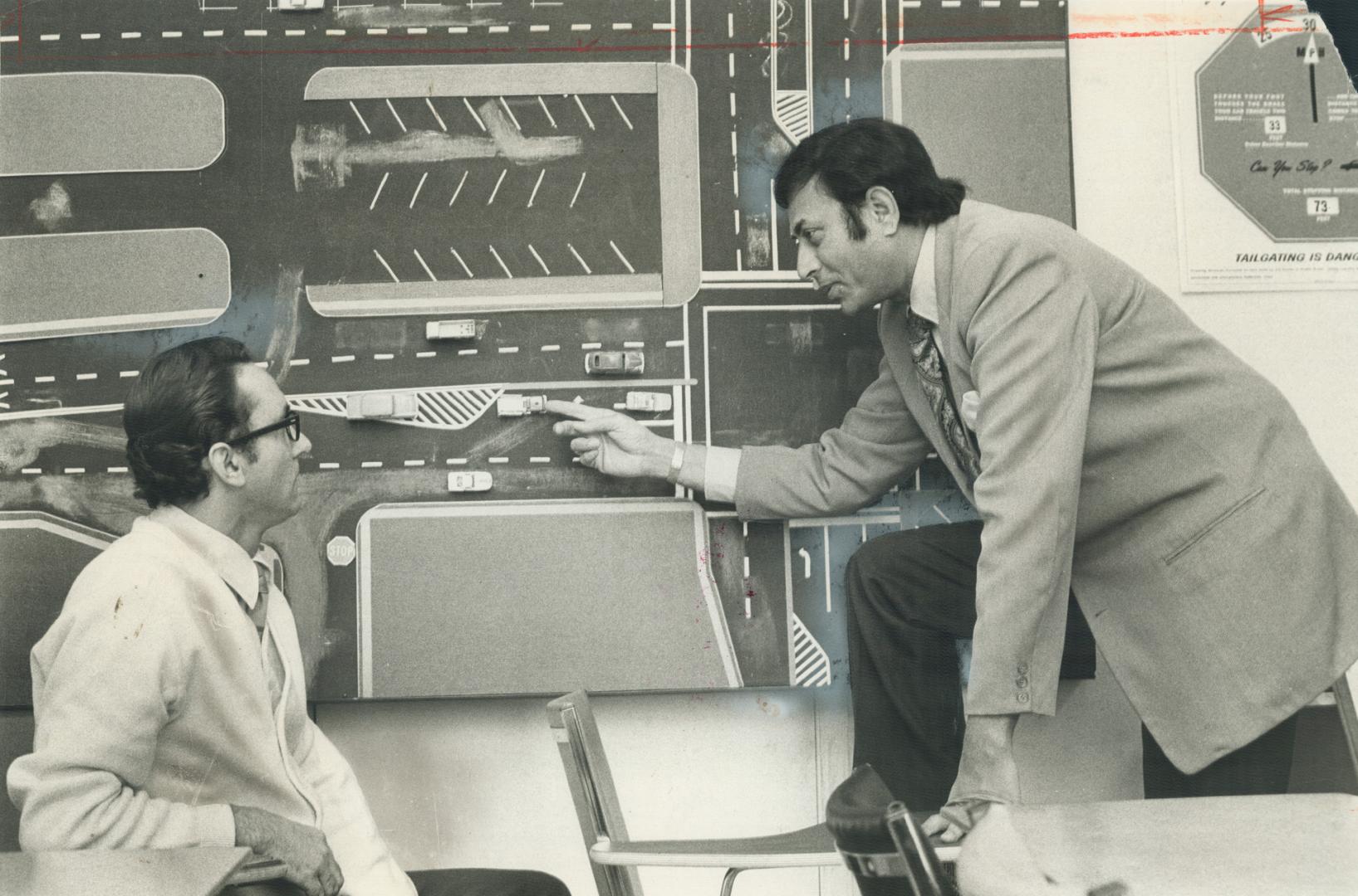 Training at no cost was offered to unemployed men with licenses by driving school president. A. Disney, right. But Disney writes that the Rehabilitation Board sent no applicants. Above, he discusses school's driving techniques with instructor Frank Gerengser, left.