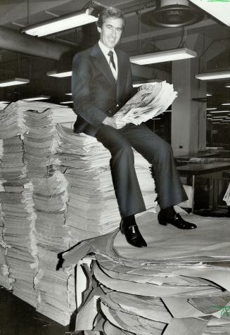 Up in the Stars: John Davis, head of Ontario Paper Co.'s newspaper recycling program, sits atop pile of old newspapars. It's one way to get attention for firm, which plans to go public.