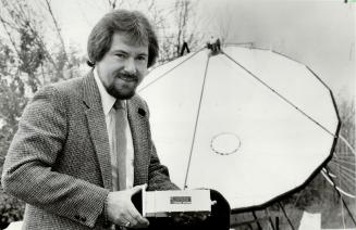 Heart of the matter: Brian Dinsdale, sales manager of MA Electronics Canada Ltd., holds small amplifier that turns satellite signals into television picture.