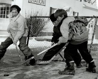 Past Master: Amateur historian Danny Dickhoff, 12, left, plays street shinny with his brother Leon, 10, right, and pal Brent McGill, 11.