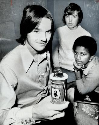 President Peter Dover holds beer can-lighter produced by his Junior Achievement company. Behind him are Jennifer Phillips, the firm's secretary, and David Leggat. The lighters sell for $3.50, including 70 cents profit.
