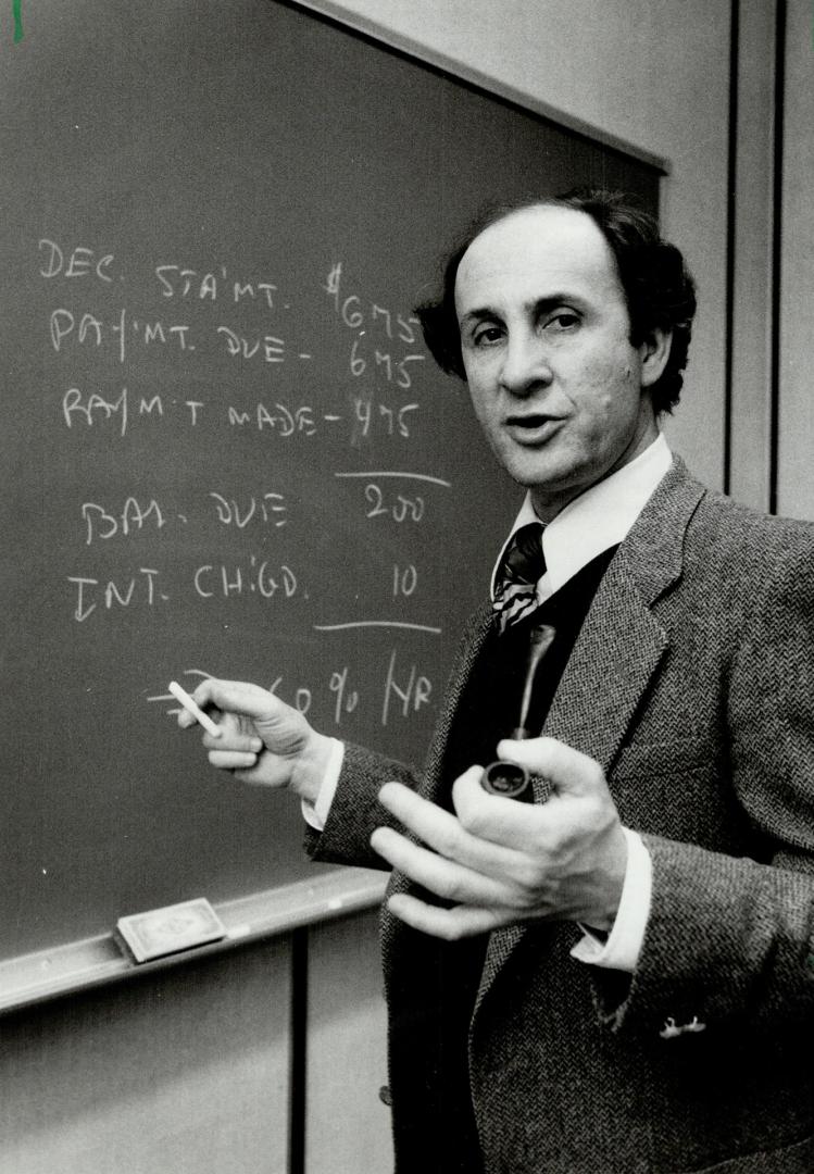Disgruntled customer: Uriel Domb, an associate professor of computer science at York University's Calumet College, demonstrates on a blackboard why he thinks the method Mastercard uses to calculate interest charges is unfair and not written clearly enough