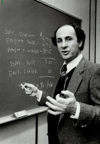 Disgruntled customer: Uriel Domb, an associate professor of computer science at York University's Calumet College, demonstrates on a blackboard why he thinks the method Mastercard uses to calculate interest charges is unfair and not written clearly enough