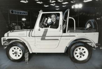 Art Ehara: Suzuki Canada Inc. president shows off one of his company's four-wheel-drive utility vehicles, to go on sale in Eastern Canada next month. Base price for cheapest Suzuki vehicle is $6,594. Engine is smaller than on some motorcycles.