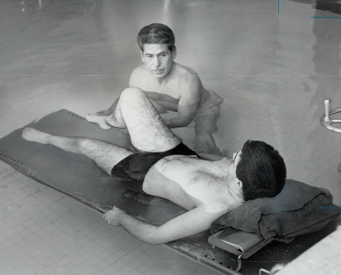 Eddie Elliott treats patient John Daniel, kitchener, He spends five hours a day in a 95-degree pool