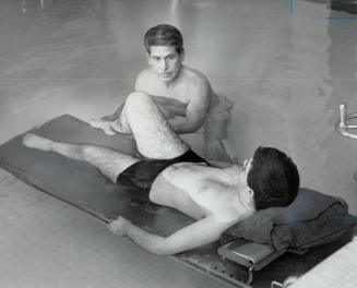 Eddie Elliott treats patient John Daniel, kitchener, He spends five hours a day in a 95-degree pool