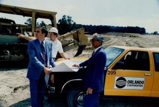 Canada's Heartland: Site superintendent Steve Birks, (hard hat) points out how the Heartland site in Mississauga is developing to Orlando founder Orey Fidani and company president Doug Kilner (far left). The 1,000-acre business park is called the largest