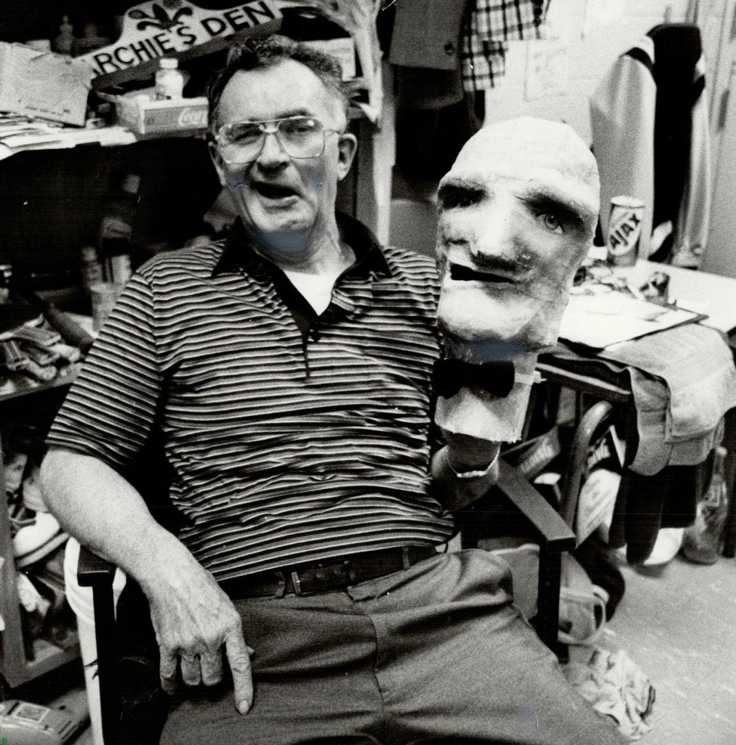 Happy man: Relaxing in his Erindale College office, Archie French, umpire, hockey trainer and amateur social worker, holds the papier-mache head that captures his zany smile.