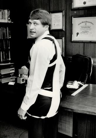 Batting injuries: Dr. Haward Fisher models The Back Strip, a harness aimed at reducing the risk of back injury.