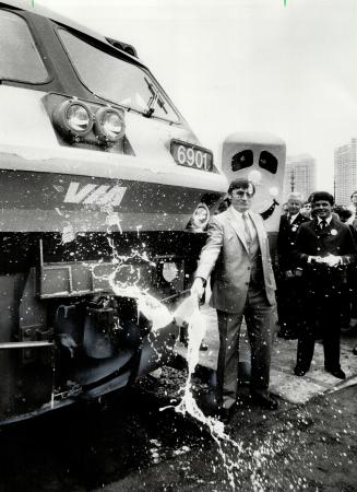 Making a splash: Via Rail president Pierre Franche smashes a bottle of champagne against the front coupling of the locomotive on the International, sending the train on its maiden voyage