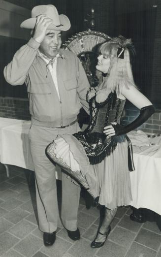 Shall we dance?, Dr. Al Goldhar, chief of staff at doffs his hat to Tami Mann, dressed as one of the saloon girls at hospital auxiliary's Saloon Night Saturday.