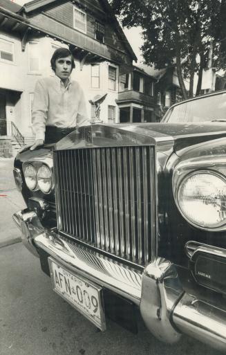 Charles Goldsmith stands beside one of the rooming houses he has made over, and the Rolls-Royce he can afford to drive because he does the thing that so no one else wants to do