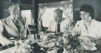 Paul Higgins, left, entertains guests Mayor Clark Mason of Ajax and Rita Law of Pickering in the dining room of his railway car