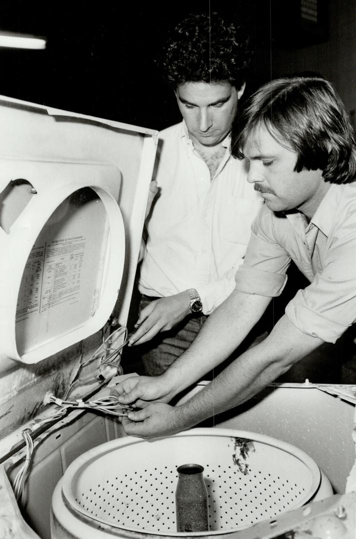Extended service: Errol Gordon, left, whose company offers a five-appliance protection plan for $99 for one year, examines a washing machine with serviceman Paul Murchison