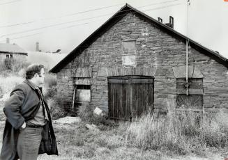 The village Smithy Stands, Mississauga Councilor Glenn Grice studies an 1867 blacksmith shop on Dundas St