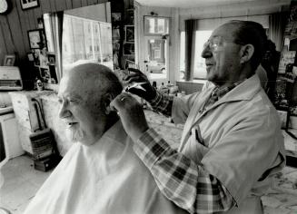 Getting clipped, Martin Lewis, 77, gets his hair cut by Pasquale Guerriero, owner of Pasquaie Barber Shop at the corner of McCaul and D'Arcy sts.