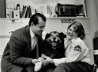 Happy Ending: Detective Constable Heinz Kruk and the humane society's Martha Schissler flank a dog found stabbed Sunday. The dog has now recovered.