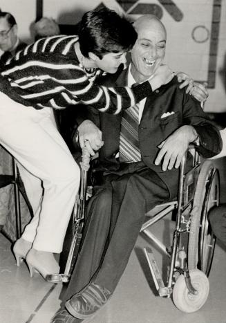 Super salesman: Cerebral palsy victim Harry Halpern receives a hug from friend Laura Toniutti after he was honored by the Canadian Cancer Society for his fund-raising efforts