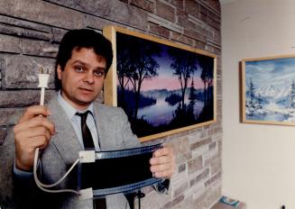 Picture worth 1,000 watts: Entrepreneur Gord Hamilton of Thornhill holds one of the radiant heat panels he uses in the art works behind him.