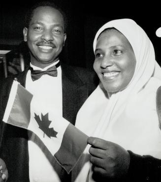 New citizen, Ethiopian-born Abdullahi Harun and his wife Zebida are all smiles as they pose with a Canadian flag as he prepares to become Canadian citizen during a mass ceremony last night at Queen's Park