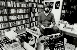 Theatre buff's delight: John Harvey, owner of Theatrebooks, sits surrounded by stacks of books and well-lined shelves