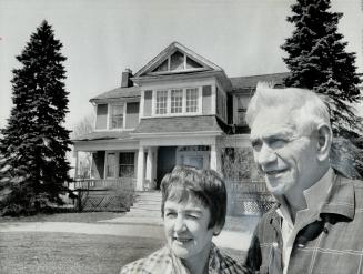 Mr. and Mrs. John Hewitt stand in front of their house, on Kingston Rd. near Brimley Rd., which will soon be pulled down to make way for a senior citizens' home. The 10-room house, made of hand-made brick, was built in 1830.