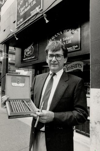 Cigar seller: Tom Hinds displays a box of Cuban cigars outside his tabacco shop on Avenue Rd.