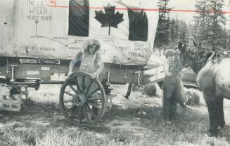 Sole survivors of the Great Canadian Wagon Train, Jon Houghton, 21, and his sister, Barb, 23, attend to come chores after pulling into Peace River Country 17 months and 2,600 miles after setting out